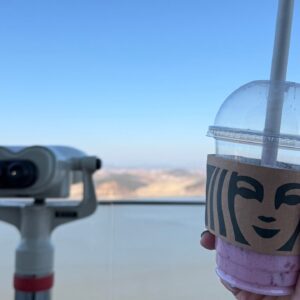 Holding a disposable Starbucks Coffee cup in front of binoculars at Aegibong Starbucks, the closest Starbucks to the DMZ