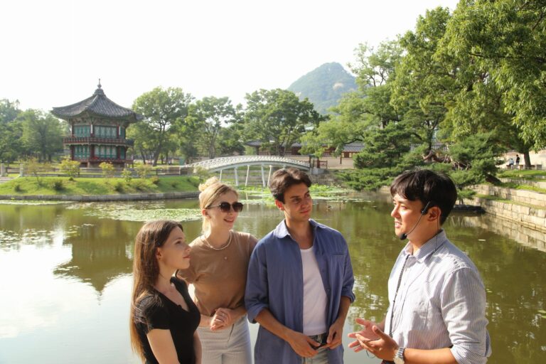 A group of friends listening to their tour guide in front of Hyangwonjeong Pavilion inside Gyeongbokgung Palace