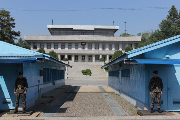South Korean JSA Border Guards standing in front of the Military Demarcation Line with North Korea's Panmungak building in the background