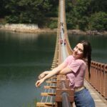 A woman enjoying the sun and admiring Majang Lake from on top of the Suspension Bridge