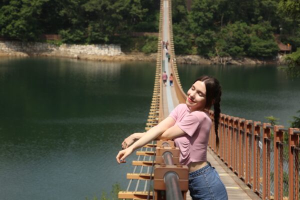 A woman enjoying the sun and admiring Majang Lake from on top of the Suspension Bridge