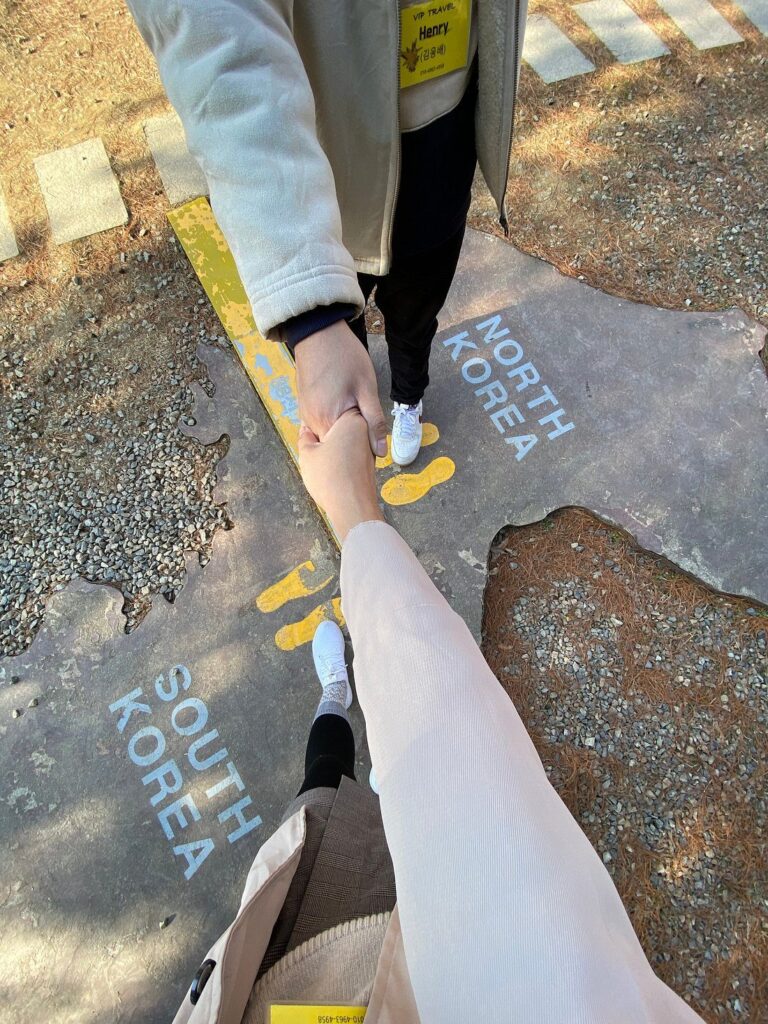 Two people shaking hands on top of a North South Korea Stone Map photo zone