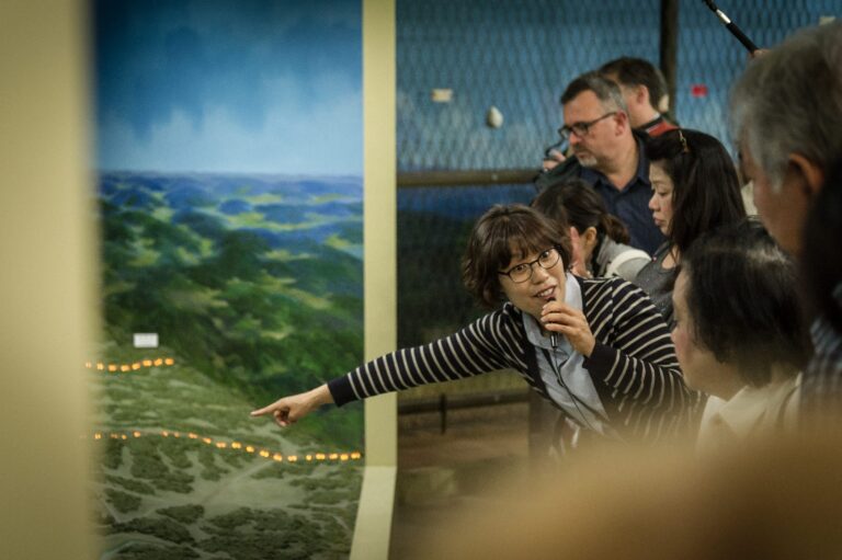 A tour guide leading a group through the DMZ Theatre Exhibition Hall