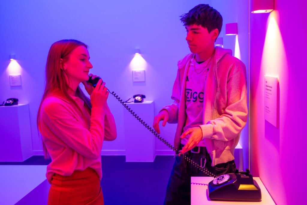 A man and woman listening to the original sound bites announcing the capture of Seoul in The Room that Still Answers at the JSA Museum