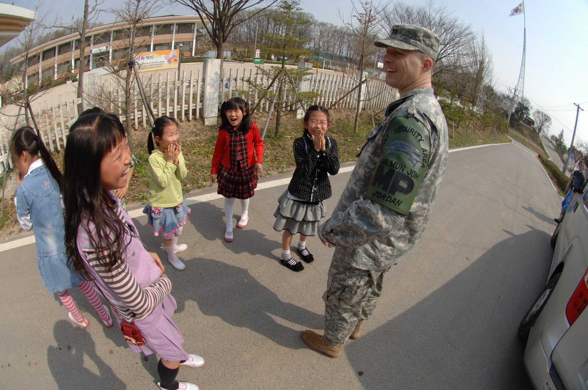A US Soldier talking with children inside the Freedom Village located within the DMZ